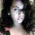 A person with curly dark hair and a light-colored top appears in a of four , with the rightmost missing