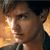 Pixelated close-up of a person's face with brown hair, wearing a dark shirt, against a warm-toned background with orange and yellow hues.
