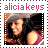 Alicia Keys in a pixelated image with pink text above, wearing a gray hat and pink top, smiling with dark hair.