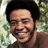Pixelated image of a smiling person with short dark hair against a blurred green background, with bold white text reading 'BILL WITHERS' on the right.