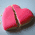 A pink heart-shaped object with a visible crack, transitioning from solid to displaying text that reads "Hope is a waking dream." in black and white lettering.