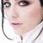 Pixelated close-up of a person's face with light skin, dark eyes, and pink lips wearing a white collared shirt.