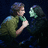 Two figures in close proximity with one figure holding the other's face, surrounded by green text reading Love Will always Last Forever on a black background.