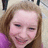 A pixelated close-up of a person with light brown hair, pinkish skin tone, and closed eyes wearing purple clothing.