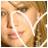 Pixelated close-up of a person's face with light skin tone, brown hair, and closed eyes against a blurred background.