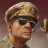Pixelated image of a person wearing a light brown cap and dark sunglasses, facing right against a gradient background.