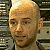 A 50x50 pixel animated buddy icon featuring a close-up of a bald person with light skin and neutral expression on the left, paired with green text reading "Original Icons .com" on a dark green background on the right.