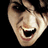 Pixelated close-up of a person's face with mouth open in laughter, red text 'BOO!' on black background.