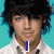 A person with dark tousled hair and a white collared shirt appears in three against a light blue background, with text elements changing across frames