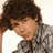 A pixelated image of a person with dark curly hair resting their head on one hand, next to green text reading 'ick loves y' on a blue background.