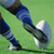 Pixelated static image of a person's lower body in motion on green background, wearing dark blue pants and white shoes with black accents.