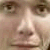 Pixelated close-up of a human face showing eyes, nose, and mouth with brown and beige tones.