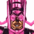 Pixelated pink character with layered headpiece and brown circular chest emblem on white background, next to green text reading 'Original Icons .com'