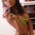 A pixelated image of a person with long brown hair wearing a yellow heart-shaped top, holding a phone, with a blurred background.