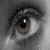 A grayscale close-up of a human eye with visible eyelashes and eyebrow, next to a pink heart-shaped icon with layered stripes on white background.