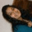 A pixelated figure with dark hair lies on a light surface, wearing a dark top and blue lower garment.