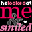 Pixelated graphic with pink and gray text on black background reading 'he looked at me & smiled' with a small white heart symbol.