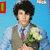 A person in a light blue shirt, brown vest, and red tie holds white flowers against a bright blue background with green text overlays.