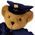 Pixelated teddy bear wearing dark blue police uniform and cap with gold emblem, standing against white background next to green with bright green text