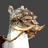 Pixelated image of a cartoon animal with brown and white fur, dark eyes, and an orange beak-like mouth against a gray background.
