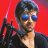 Pixelated static image of a person with dark hair and blue sunglasses against a red background, wearing a dark jacket over a light shirt.