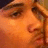 A pixelated close-up of a person's face with orange-toned skin and brown hair, next to red text reading 'Him <3' on a black background.