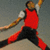 A person in a red sleeveless shirt and black pants performs a dynamic pose with arms extended, legs spread wide apart.