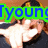 A pixelated image of a person wearing a dark cap with yellow trim, making a hand gesture near their face