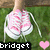 A pixelated image shows a person in pink and white sneakers standing on green grass with a black banner reading 'bridget' at the bottom.