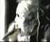 A grayscale animated sequence shows a person with long hair holding a microphone, transitioning from left to right