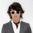 Pixelated image of a person with brown hair wearing sunglasses and a gray jacket over white shirt, next to text reading "Joe Jonas" and "<3 HOT" on dark blue background.