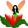 Pixelated fairy with black hair and green dress sits on red heart-shaped flower with green leaves, wings shift from orange to pink gradient.