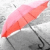 Static 50x50 pixel icon showing a pink and red umbrella with black handle against gray background, rendered in low-resolution pixel art style.