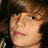 A pixelated image of a person with brown hair and light skin, featuring pink text overlay in two states.
