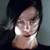 Pixelated close-up of a person's face with dark hair, light skin, and a neutral expression against a muted background.