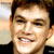 Static 50x50 pixel icon showing a close-up of a smiling person with short brown hair, visible teeth, and light skin tone against a blurred background.