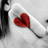 A static pixelated image shows a red heart-shaped balloon with a black string against a light gray background, partially obscured by dark vertical shapes on the left.