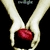 Two hands hold a red heart against black background with text and pixelated elements.