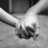 Black-and-white image of two hands clasped together with overlaid text in pixelated font.