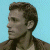Pixelated profile of a person with brown hair against light blue background, adjacent to green with bright green text