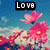 Pixelated image with 'LOVE' text in white block letters on black background above pink flowers against blue sky.