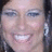Pixelated close-up of a smiling person with light skin, visible teeth, and dark hair, cropped to show only the upper face and part of the ear.