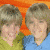 A 2x2 contact sheet of four animated frames showing two young characters in various poses against different colored backgrounds with visible pixelation and dithering effects.