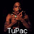 Pixelated image of a shirtless figure with brown skin and green accents on the face, holding an object near the chest against a black background.