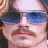 Static 48x48 pixel buddy icon showing a close-up of a person's face with blue-tinted sunglasses, mustache, and light skin tone against a blurred background.