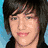 Pixelated portrait of a person with dark hair and blue eyes, wearing a black top against a blue background.
