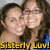 Two people with dark hair smiling closely together, yellow text reading 'Sisterly Love!' at the bottom.