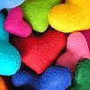 A dense cluster of colorful heart-shaped icons in various hues including red, pink, blue, green, yellow, and cyan, overlapping in a close-up view.