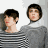 Two figures in gray sweaters stand side-by-side; one figure's head is replaced by a white circle while text appears below.