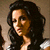 Pixelated image of a person with long dark hair, light skin tone, and visible facial features including eyes, nose, mouth, and ear.